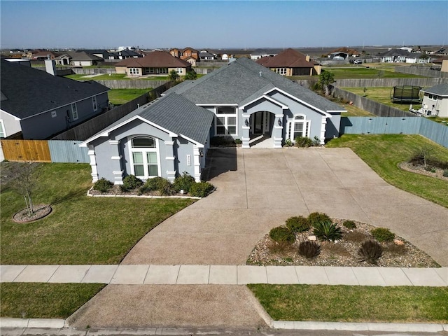 view of front of home featuring a residential view, a front lawn, and fence