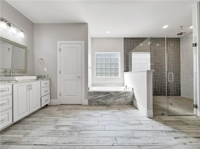 full bath with wood tiled floor, vanity, a garden tub, and a shower stall