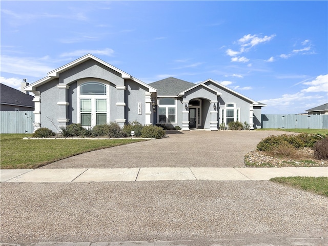 ranch-style house with aphalt driveway, stucco siding, a front yard, and fence