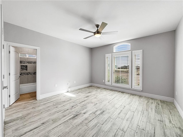 unfurnished bedroom featuring baseboards, ceiling fan, a spacious closet, a closet, and light wood-type flooring