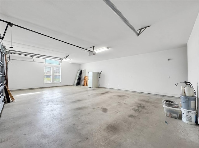 garage with a garage door opener and freestanding refrigerator