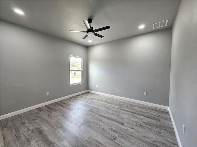 unfurnished room with ceiling fan, recessed lighting, wood finished floors, and visible vents