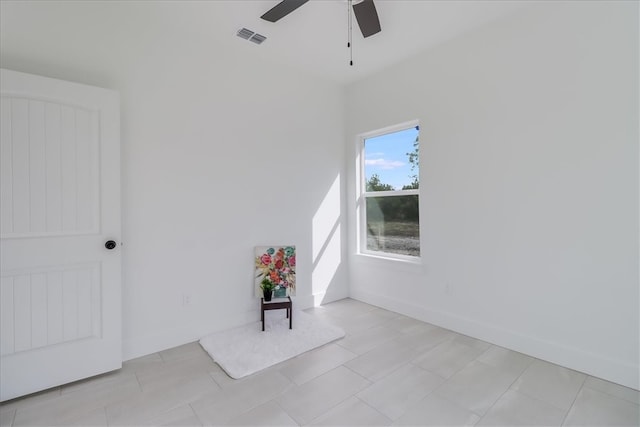 tiled spare room featuring ceiling fan