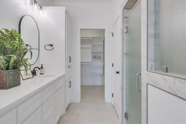 bathroom featuring vanity, a shower with shower door, and tile patterned floors