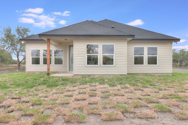 rear view of house featuring a lawn