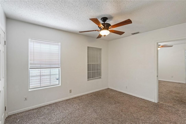 carpeted empty room featuring a textured ceiling