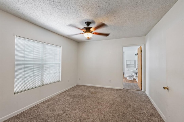 carpeted spare room featuring ceiling fan and a textured ceiling