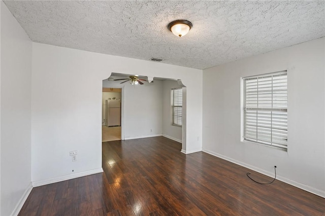 spare room with dark hardwood / wood-style floors, ceiling fan, and a textured ceiling