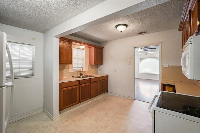 kitchen with ceiling fan, sink, and white appliances