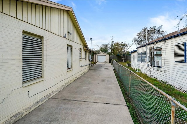 view of property exterior featuring cooling unit, a garage, and an outbuilding