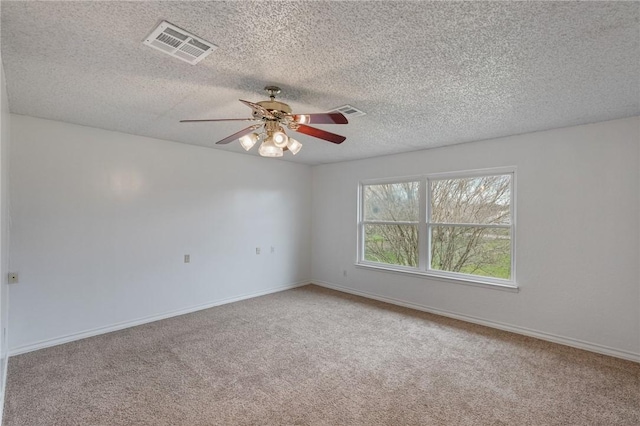 spare room featuring ceiling fan, carpet, visible vents, and baseboards