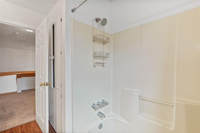 full bathroom with a textured ceiling and washtub / shower combination