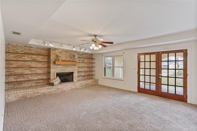 unfurnished living room featuring french doors, a brick fireplace, carpet flooring, and visible vents