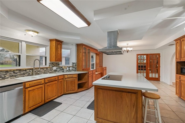 kitchen featuring island range hood, a sink, a kitchen island, light countertops, and appliances with stainless steel finishes