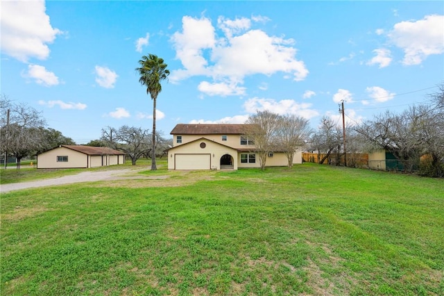 view of front of home featuring an attached garage, driveway, a front yard, and fence