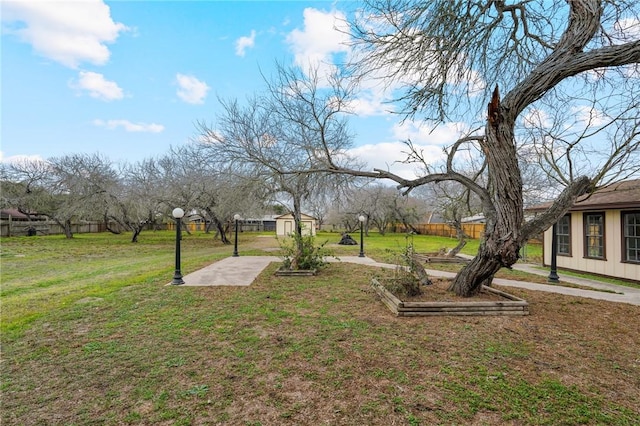 view of yard with a patio area, a shed, an outdoor structure, and fence