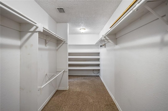 walk in closet with visible vents and dark carpet