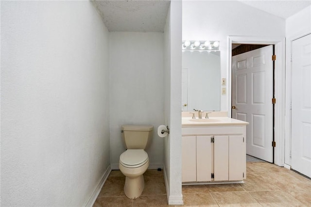 bathroom featuring toilet, baseboards, vanity, and tile patterned floors