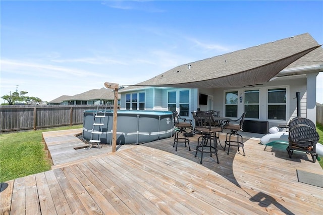 deck with a fenced in pool and ceiling fan