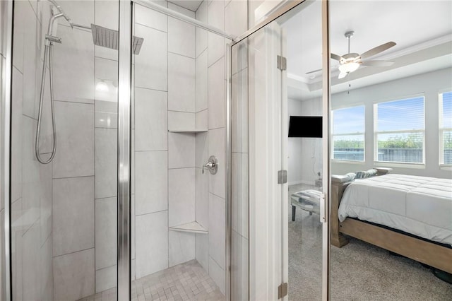 bathroom featuring ceiling fan, a shower with shower door, and crown molding