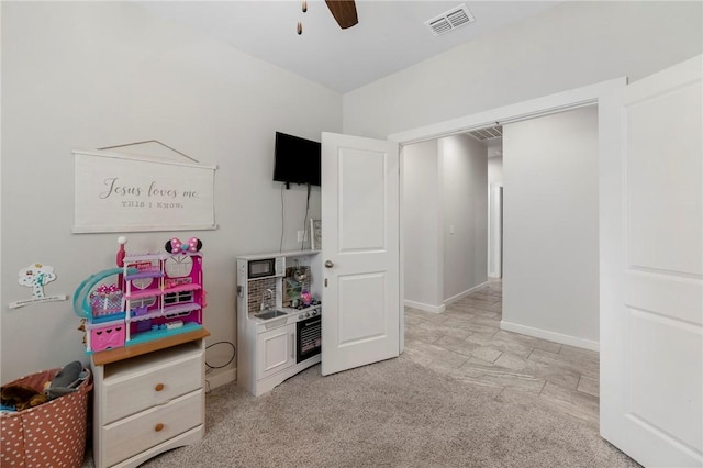 playroom with ceiling fan and light colored carpet