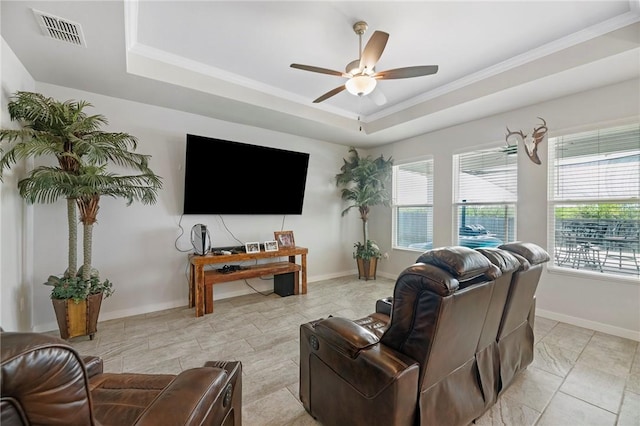 living room with ceiling fan, a healthy amount of sunlight, a raised ceiling, and crown molding