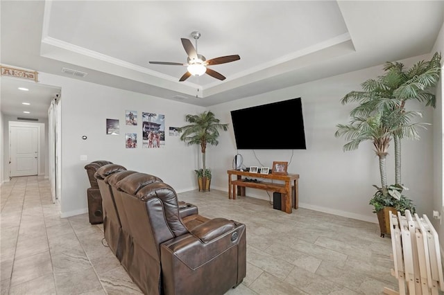 living room with ceiling fan, a raised ceiling, crown molding, and radiator