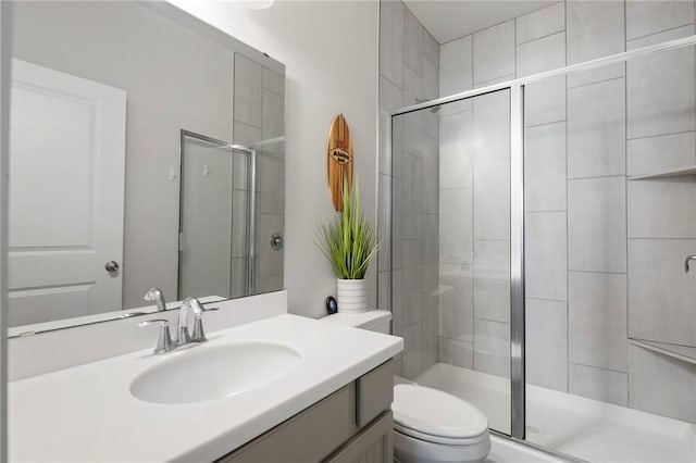 bathroom featuring vanity, toilet, and a shower with shower door