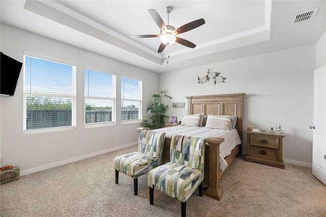 bedroom with a raised ceiling, ceiling fan, and light carpet