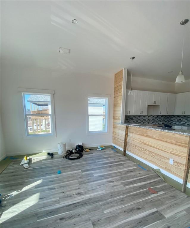unfurnished living room featuring baseboards and wood finished floors