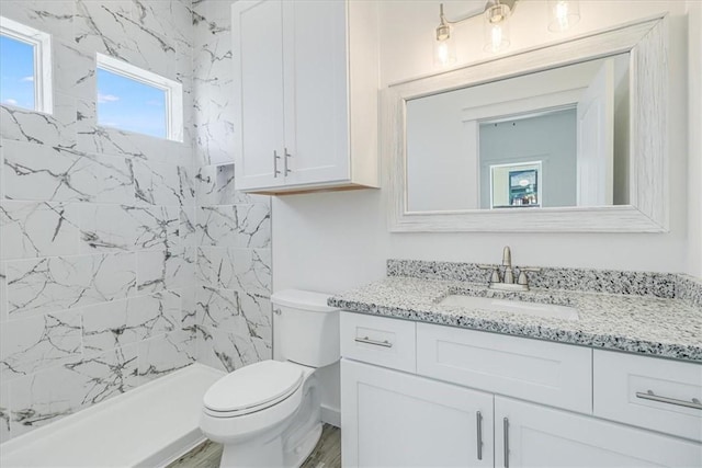 235 Port Mansfield St, Port Aransas, TX 78373 - bathroom featuring vanity, toilet, tiled shower, and wood finished floors