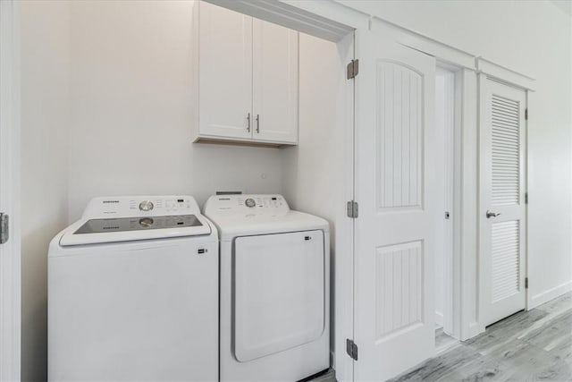 235 Port Mansfield St, Port Aransas, TX 78373 - washroom with cabinet space, light wood-style flooring, and separate washer and dryer