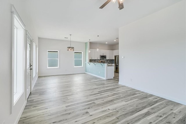 235 Port Mansfield St, Port Aransas, TX 78373 - unfurnished living room with ceiling fan, light wood-style floors, baseboards, and recessed lighting