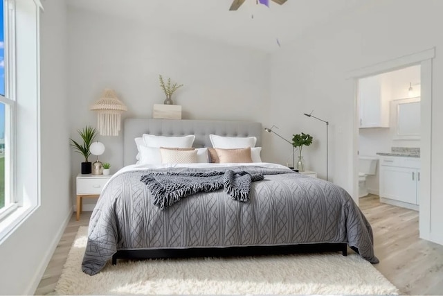 235 Port Mansfield St, Port Aransas, TX 78373 - bedroom with light wood finished floors, connected bathroom, baseboards, and a ceiling fan