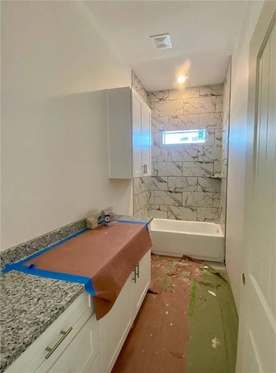 bathroom featuring  shower combination, vanity, and visible vents