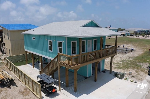 235 Port Mansfield St, Port Aransas, TX 78373 - back of house featuring roof with shingles and a carport