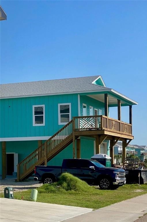 view of front facade featuring stairway and a shingled roof