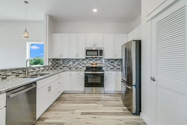 235 Port Mansfield St, Port Aransas, TX 78373 - kitchen with appliances with stainless steel finishes, a sink, white cabinetry, backsplash, and recessed lighting