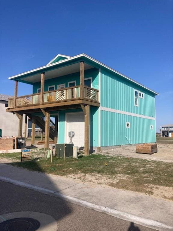 exterior space featuring board and batten siding, an attached garage, and stairway