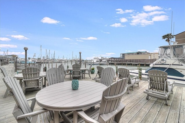 deck with outdoor dining space and a water view