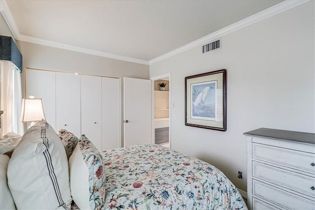 bedroom featuring a closet, visible vents, and crown molding