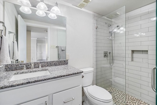 bathroom with toilet, a stall shower, visible vents, and vanity