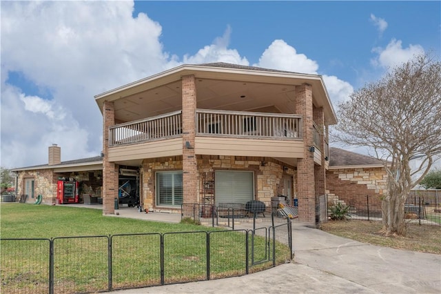 rear view of house with a yard and a balcony