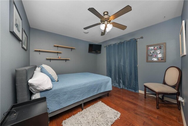 bedroom with ceiling fan and dark wood-type flooring