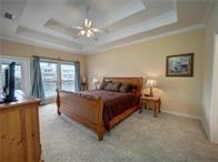 15230 Isabella Ct, Corpus Christi, TX 78418 - bedroom with ornamental molding, light carpet, a tray ceiling, and baseboards