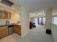 15230 Isabella Ct, Corpus Christi, TX 78418 - kitchen with brown cabinetry, dishwasher, glass insert cabinets, and baseboards