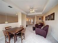 15230 Isabella Ct, Corpus Christi, TX 78418 - dining area featuring a ceiling fan, light carpet, and a raised ceiling