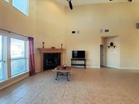 15230 Isabella Ct, Corpus Christi, TX 78418 - tiled living room featuring a high ceiling and a fireplace
