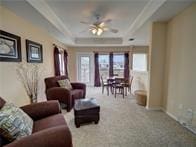 15230 Isabella Ct, Corpus Christi, TX 78418 - carpeted living room with ceiling fan and a tray ceiling