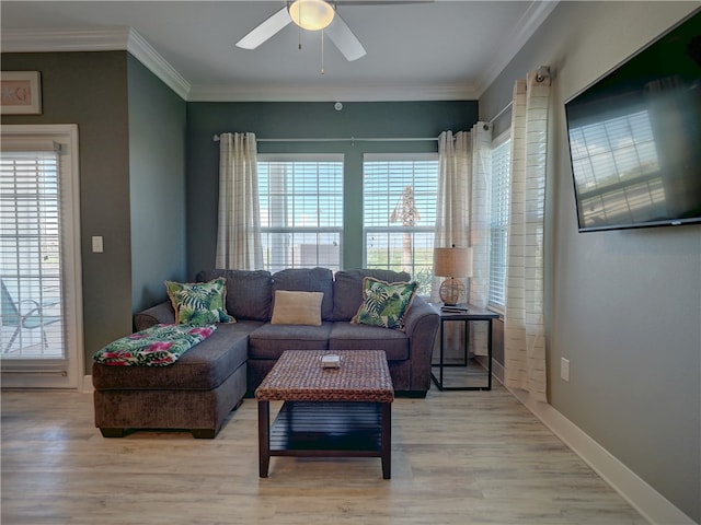 living room featuring ceiling fan, a wealth of natural light, wood-type flooring, and ornamental molding